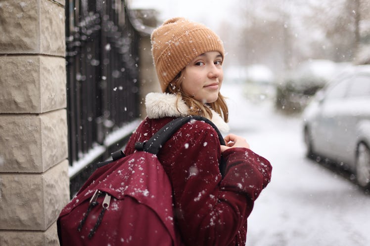 Young woman walking in winter snow during 2023's final Mercury retrograde on December 13.