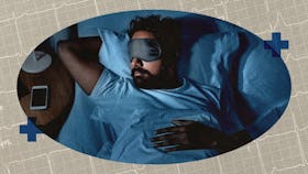 A man in a sleep mask in bed.