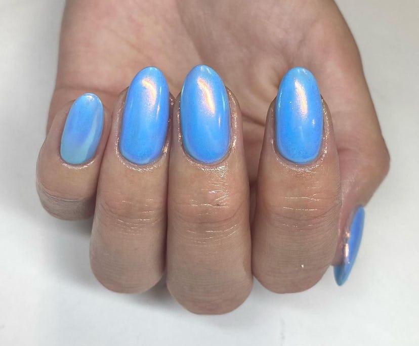 "Frosted" blue chrome nails are an on-trend holiday nail polish color for 2023.