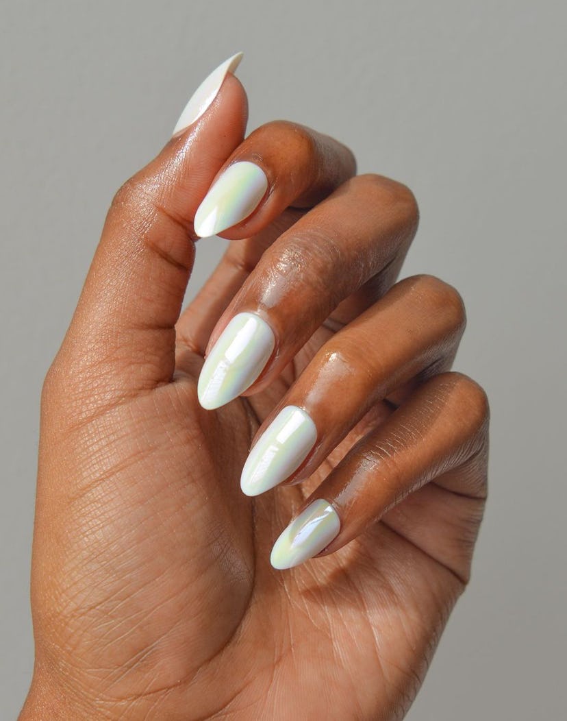 Pearly white nails are an on-trend holiday nail polish color for 2023.