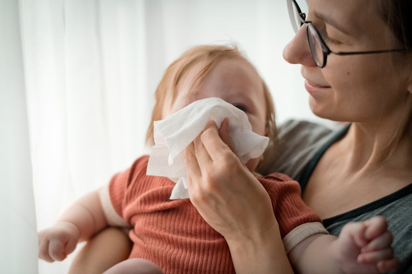Mother helping her little child to clean nose; what to do if infant has rsv