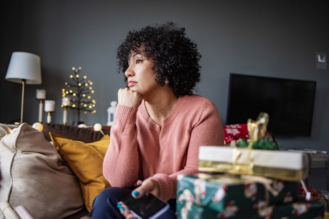 A woman sits alone in her home during the holiday season.