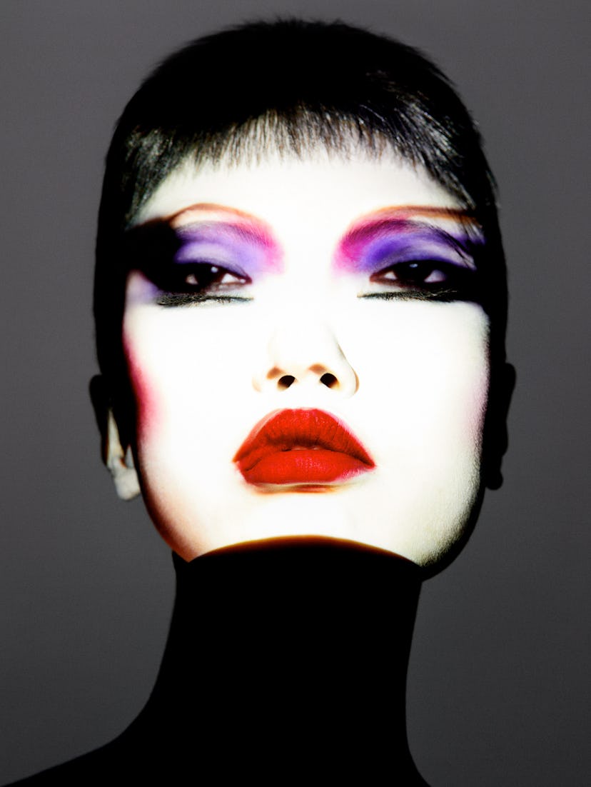 a photograph of a woman with multicolored makeup