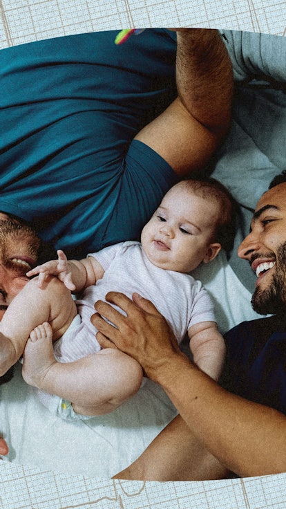 Two gays dads cuddling their baby.