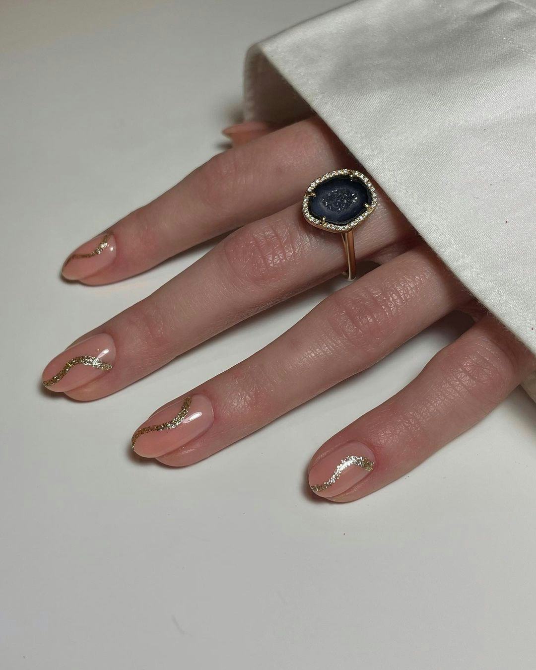 Abstract swirls are a simple manicure design idea for short almond New Year&rsquo;s Eve 2023 nail art.