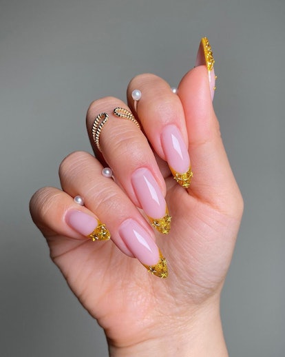 Gold French tip nails with stars are an on-trend manicure idea for New Year's Eve 2023 nails.