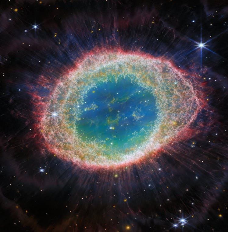  This image of the Ring Nebula appears as a distorted doughnut. The nebula’s inner cavity hosts shad...