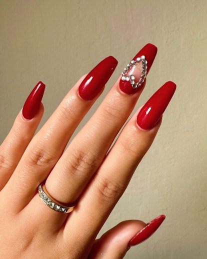 Red nail polish with a rhinestone heart are are a cute & simple manicure design idea for New Year's ...