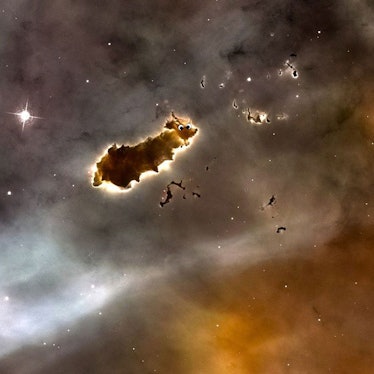 Photo of a cloud of dark gas in space which looks a bit like a caterpillar, with googly eyes added