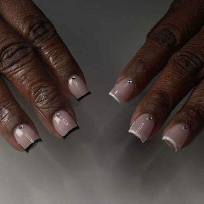 Short, square-shaped micro French tips with studs are a simple manicure design idea for New Year's E...