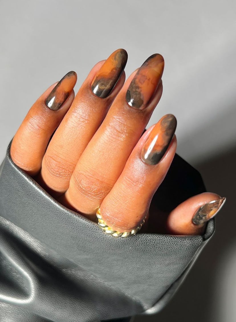 Coffee-colored swirled nail art is an on-trend Capricorn nail design for 2024.