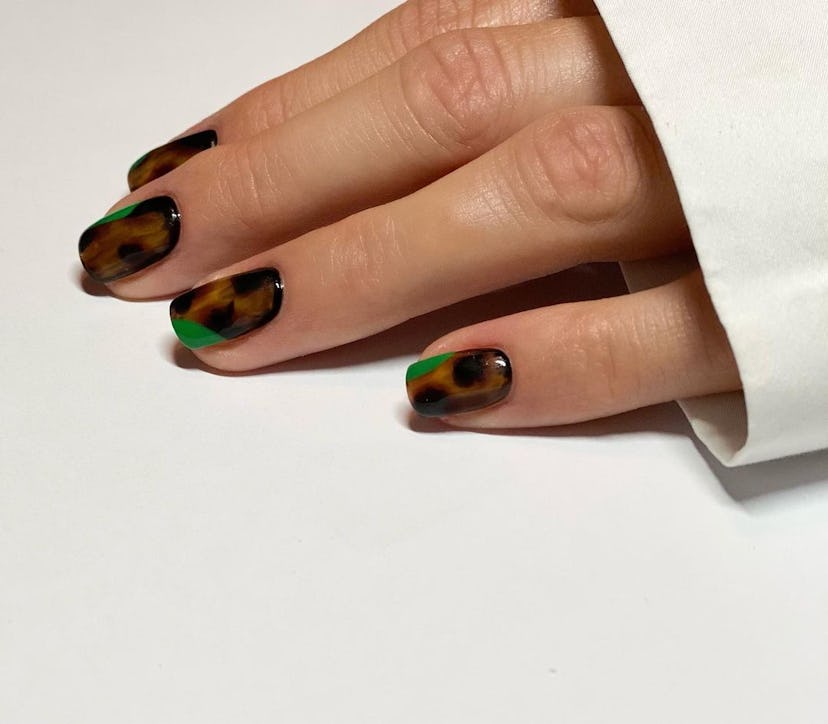 Tortoiseshell nails with a pop of green polish are an on-trend Capricorn nail design for 2024.