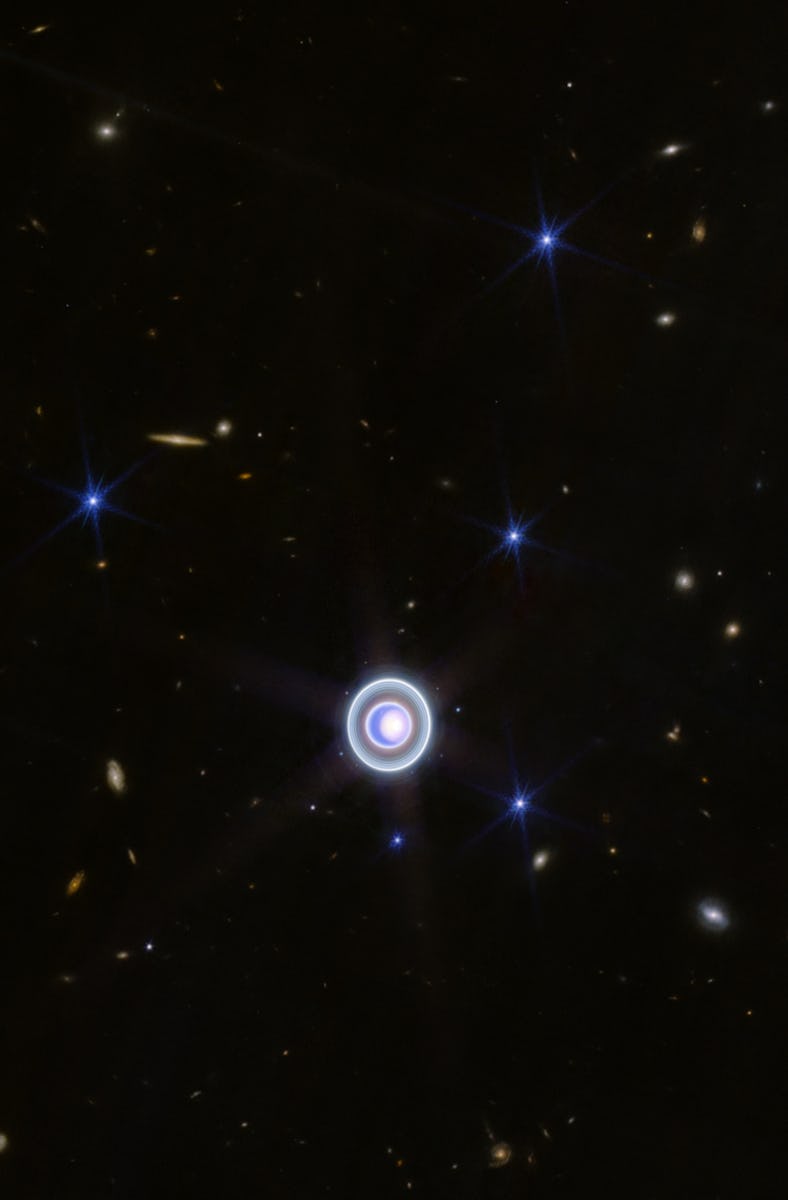 a blue planet with rings amid a backdrop of stars and galaxies