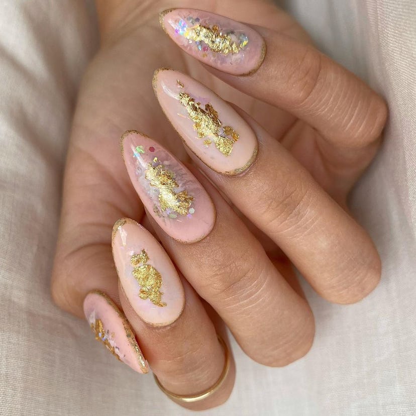 A peach fuzz manicure with gold leaf detailing is on-trend for a 2024 “peach fuzz” manicure.