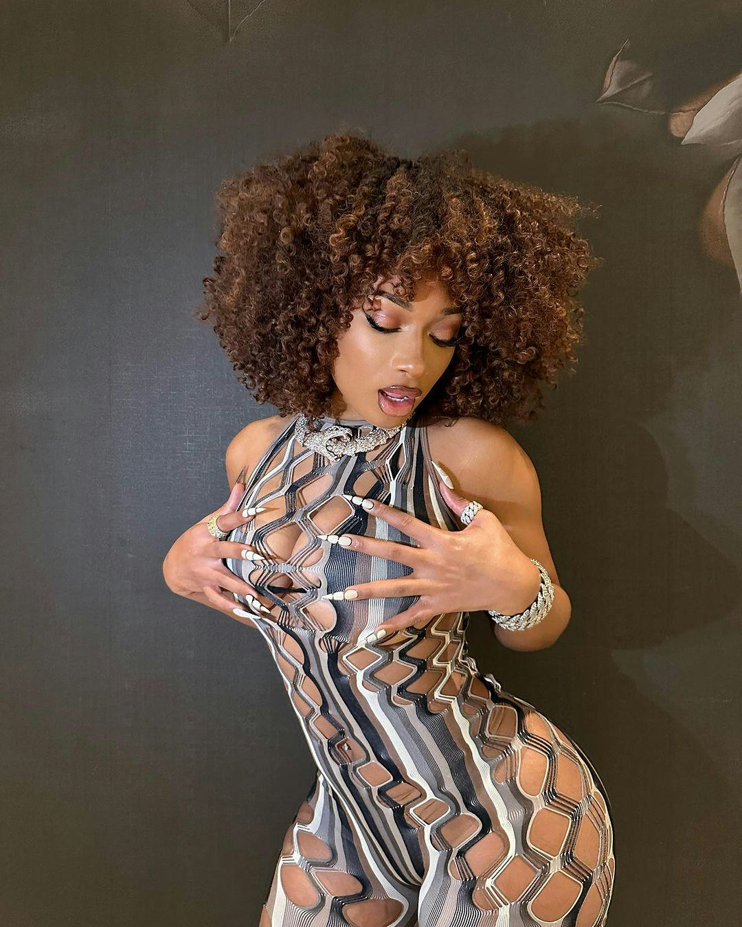 Megan Thee Stallion wears a printed catsuit with multiple cut-outs.