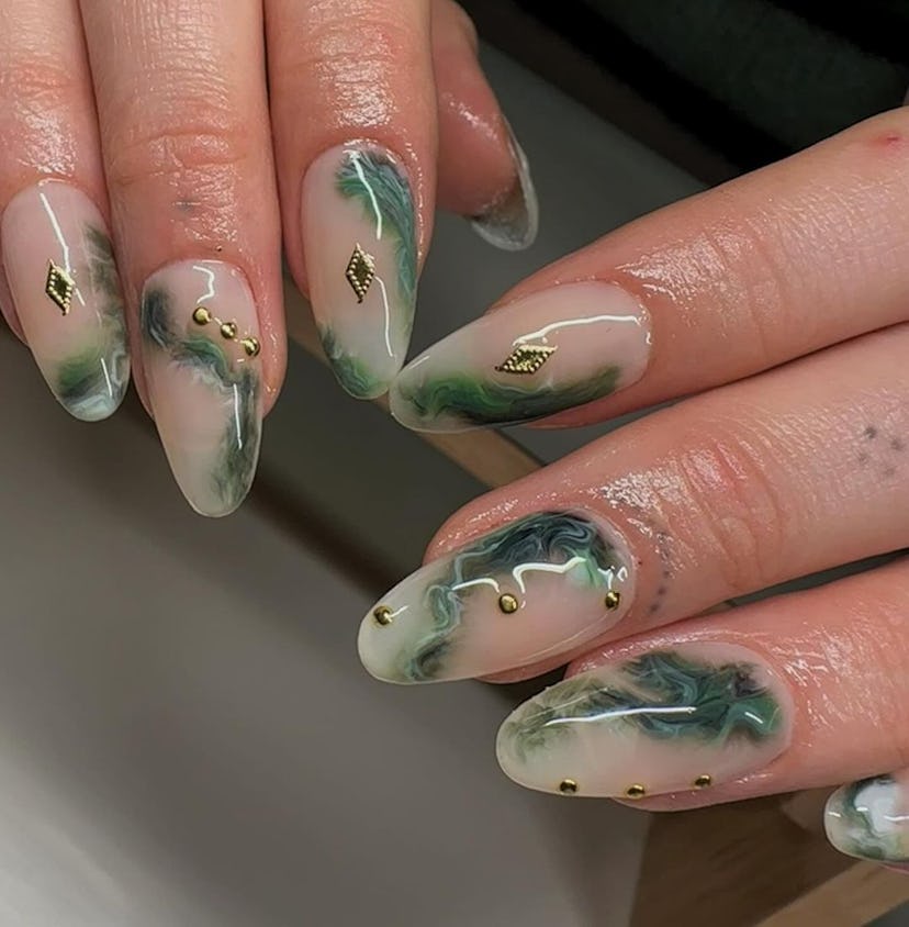 Olive green marbled manicures are an on-trend Capricorn nail design for 2024.