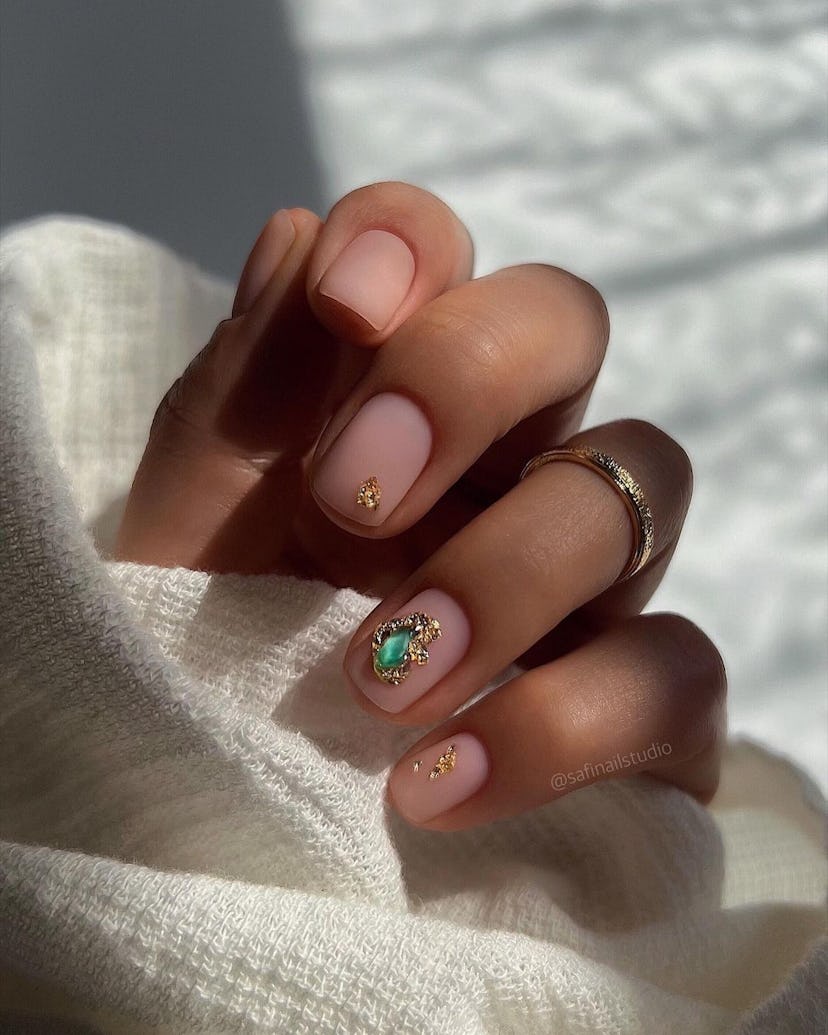 Neutral nails with colorful gems are an on-trend Capricorn nail design for 2024.