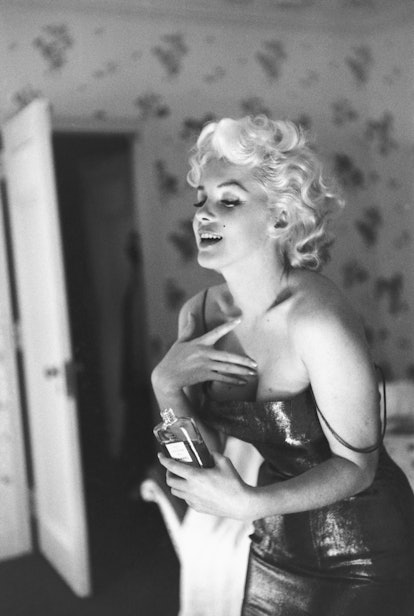 Actress Marilyn Monroe poses for a candid portrait with a bottle of Chanel No. 5 perfume on March 24...