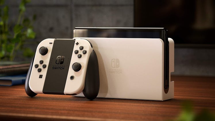 The Nintendo Switch OLED docked next to it's Joy-Con controllers.