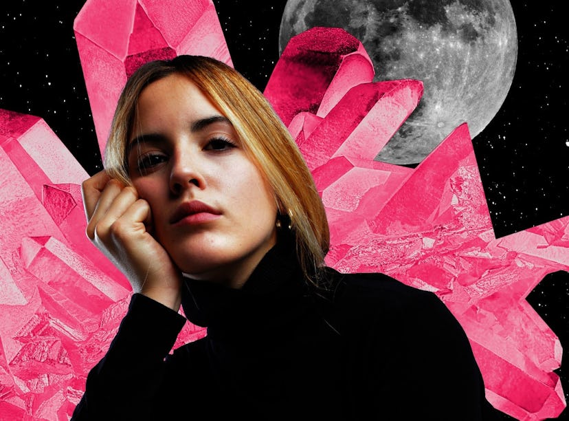 Young woman with crystals and a moon behind her to show that your 2024 yearly horoscope is full of a...