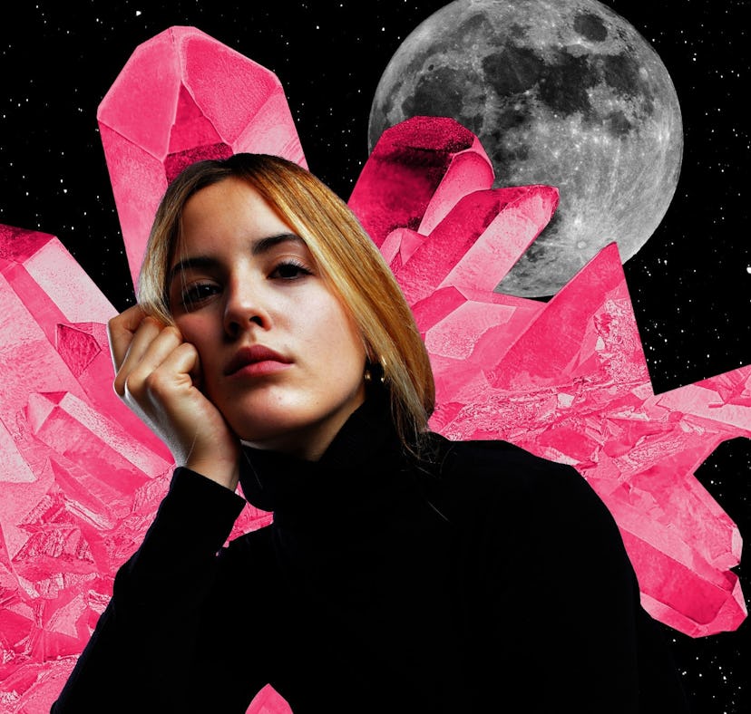 Young woman with crystals and a moon behind her to show that your 2024 yearly horoscope is full of a...