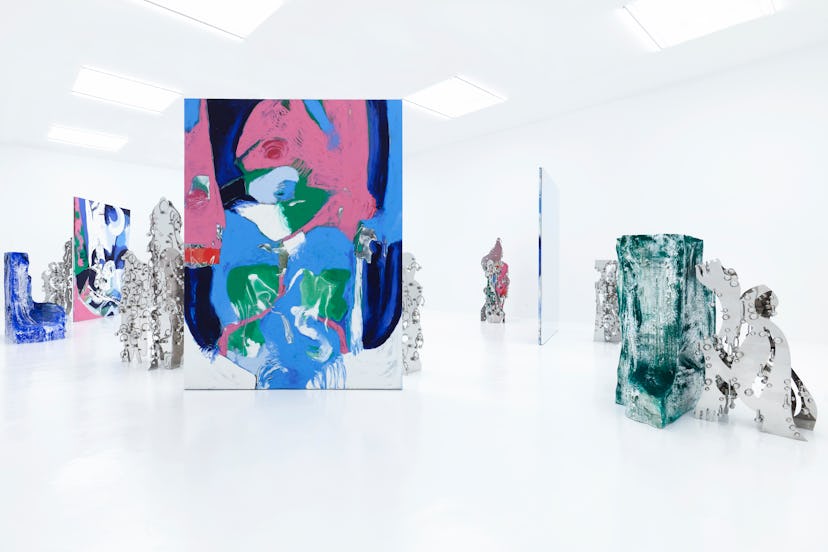 art installation with silvery mirrored pieces and larger scale abstract paintings in pink, blue, gre...