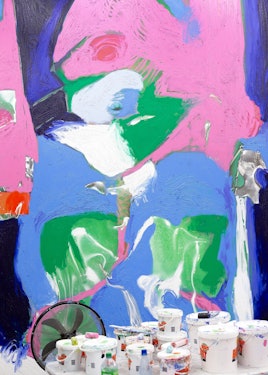image of a pink, blue, and green painting with paint cans in front of it at the artist's studio
