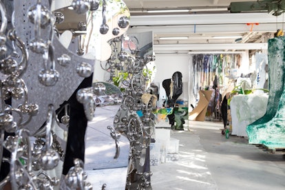 Artist Donna Huanca's studio, with silvery sculptures in the left foreground and other supplies and ...