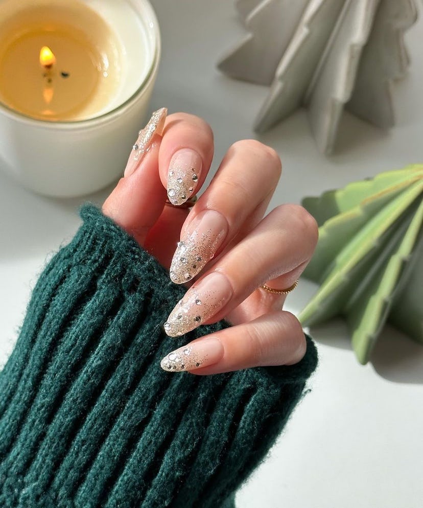 Silver glitter ombre nails with rhinestones are classy manicure inspiration for holiday nails in 202...