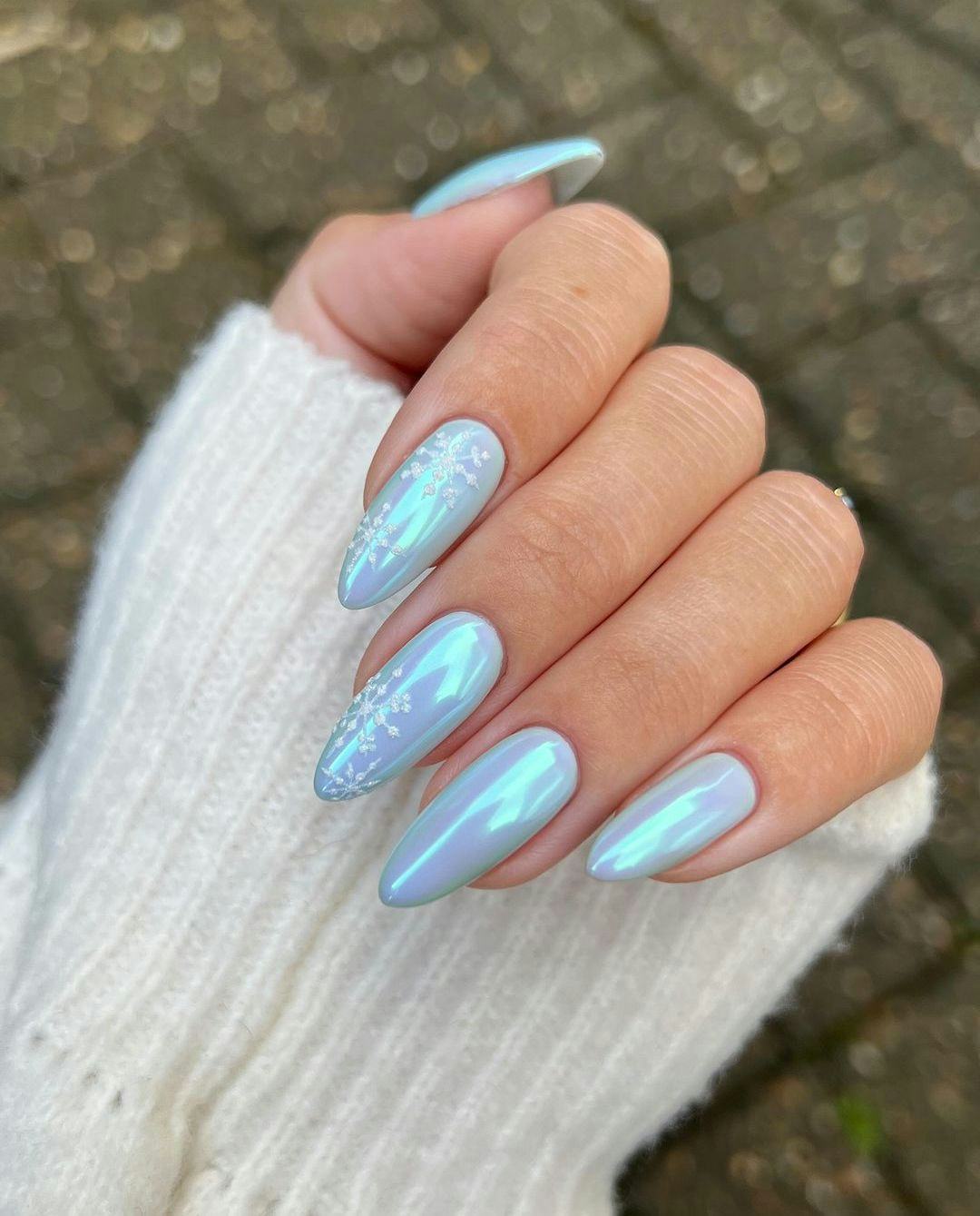 Light blue chrome nails with simple snowflake nail art are a festive manicure idea for holiday nails&hellip;