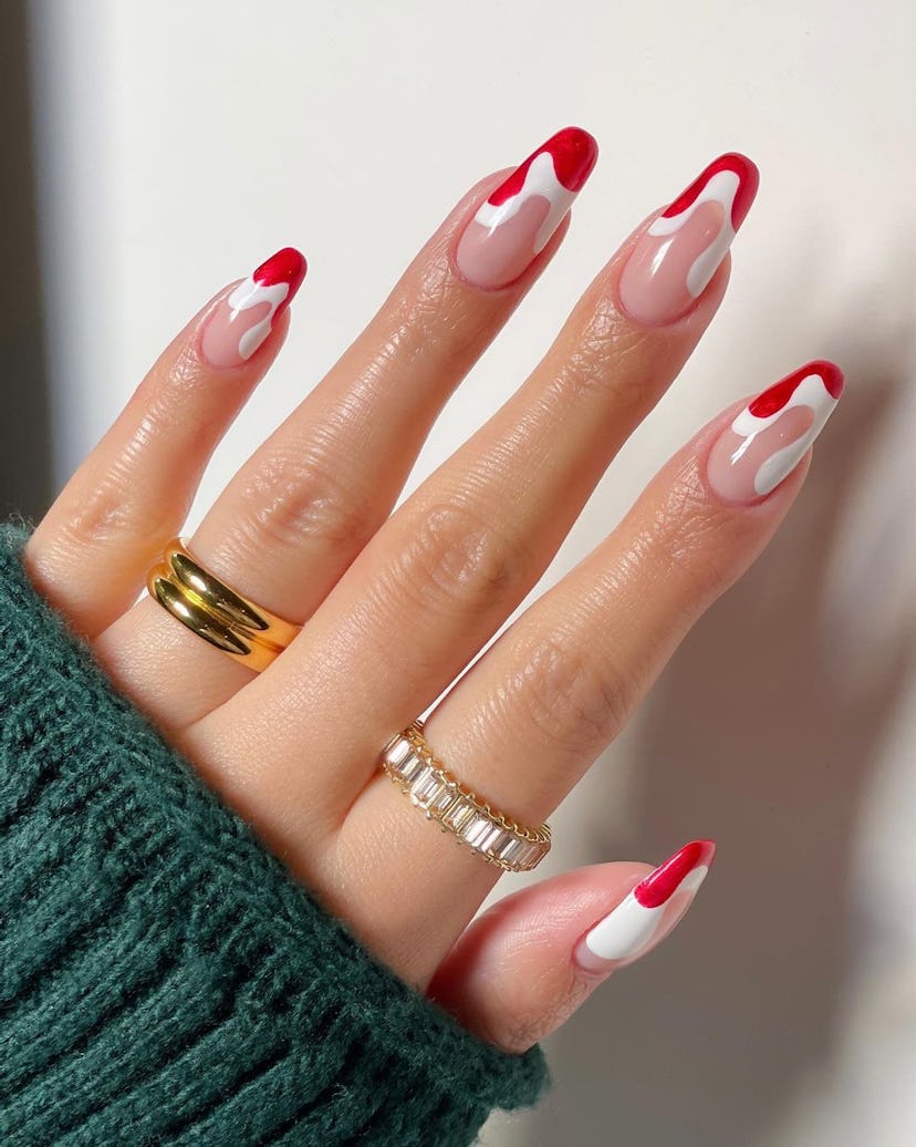 Abstract red and white Santa hair French nails are a festive holiday nail design for Christmas 2023.