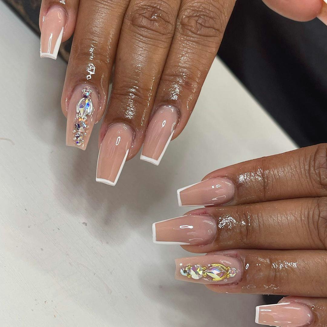 &ldquo;More is more&rdquo; mismatched gemstone nails are an on-trend idea for holiday nails in 2023.