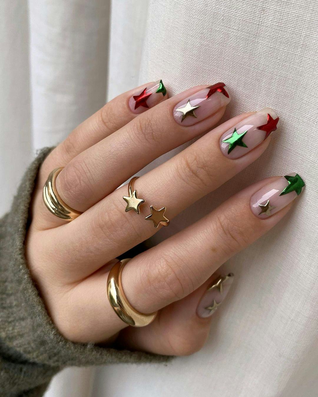 Clear nails with red, green, and silver chrome stars are a festive holiday nail design for Christmas&hellip;