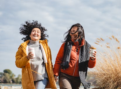 A pair of friends holding coffee and laughing during the February 2023 full Snow Moon.