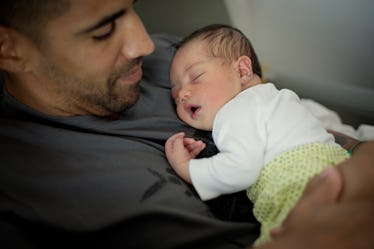 A dad holding his newborn baby.