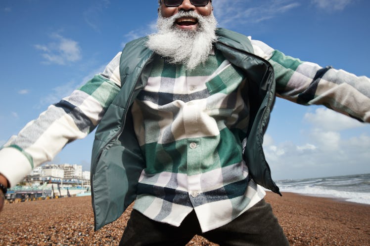 An energized older man on a beach. 