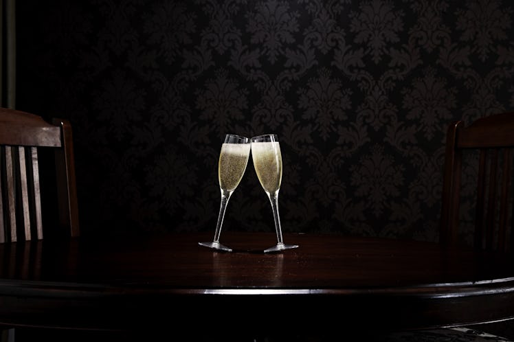 Two clinking champagne glasses on dark background