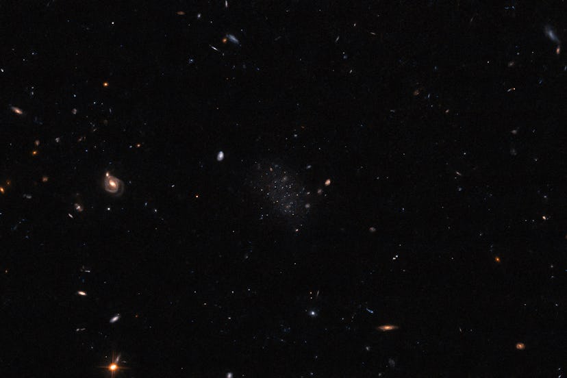 A black, mostly empty field with a variety of stars and galaxies spread across it. Most are very sma...