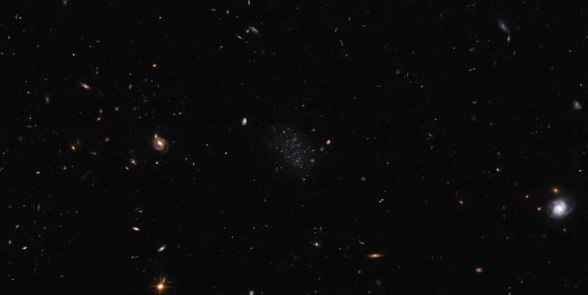 A black, mostly empty field with a variety of stars and galaxies spread across it. Most are very sma...