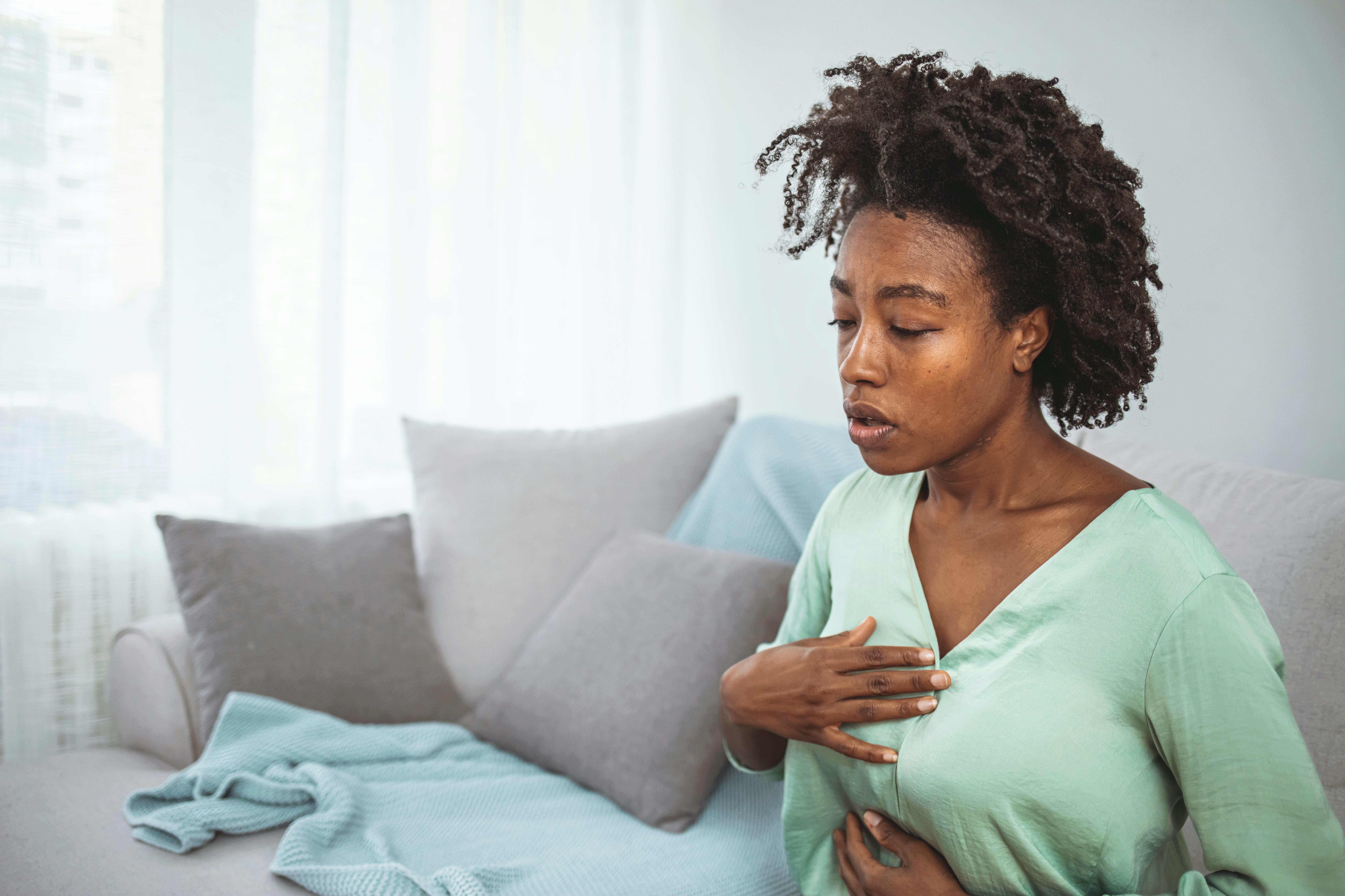 woman with heartburn clutching her chest
