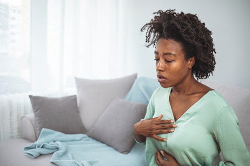 woman with heartburn clutching her chest
