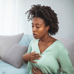 woman with heartburn clutching her chest