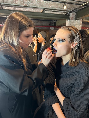 A model getting their makeup done backstage at Rodarte F/W '23