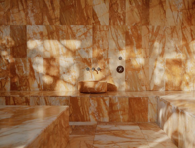 a hammam in a spa covered in amber-hued marble tiles