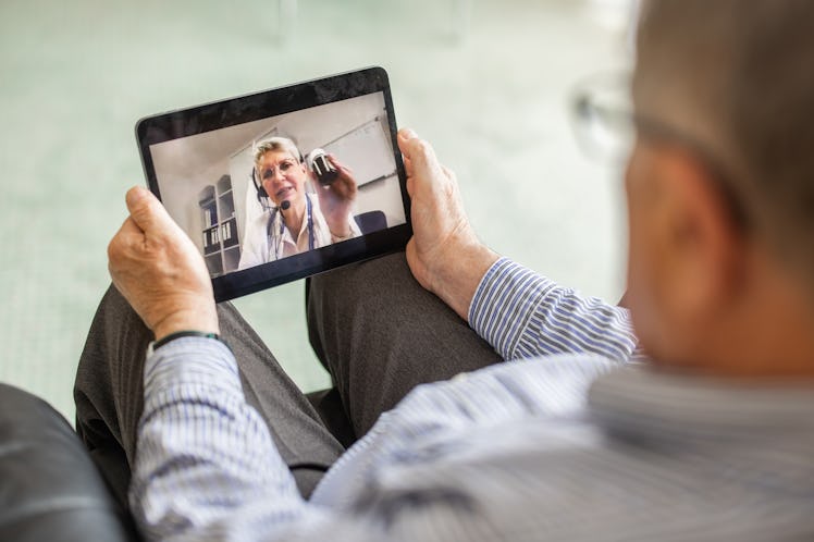 Man having online consultation with female doctor at home on digital tablet. Doctor explaining medic...