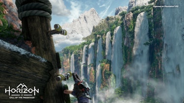 A series of waterfalls can be seen in the distance as a hand reaches up to a grappling bar.