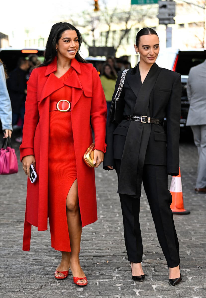 Hannah Bronfman is seen wearing a red Michael Kors coat and dress with a gold bag with Olivia Perez ...