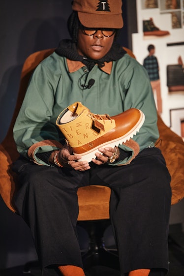 the artist Nina Chanel Abney holding a timberland boot of her design