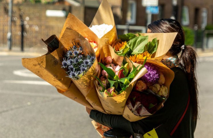 a person holding bundles of flower arrangements