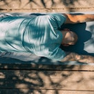 A man in child's pose on a yoga mat.